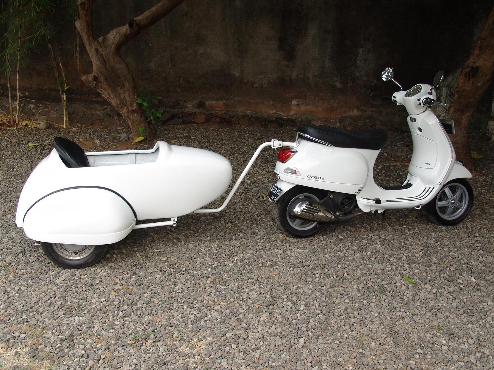 Fiberglass Vespa sidecar with 10-inch steel wheel and carpeted interior